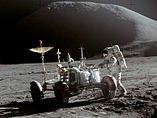 Джеймс Ирвин у «Лунного Ровера». На заднем плане — гора Хэдли. Снимок сделан в самом конце первого выхода на поверхность Луны