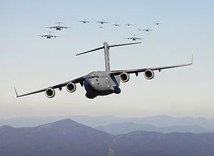 Thirteen C-17 Globemaster III aircraft fly ove...