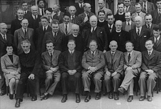 Photo en noir en blanc d'un groupe de scientifiques, comportant presque exclusivement des hommes.