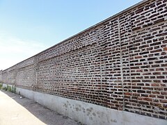 Le mur d'enceinte subsiste dans la partie sud-ouest du carreau.