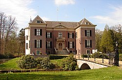 Red brick front of the building with a stone bridge leading to the entrance