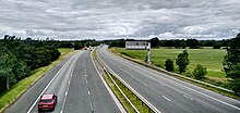 The M6 motorway is the longest motorway in the United Kingdom. It is located entirely within England, running for just over 230 miles (370 km) from the Midlands to the border with Scotland. M6 motorway between Junctions 43 and 44 (looking north from Linstock Bridge).jpg