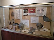 Photographie de poteries antiques exposées derrière une vitrine.