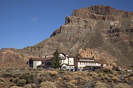 Bâtiment au pied d'une montagne aux parois raides.