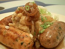 Isang plato ng mga tsoriso at minasang patatas, na may repolyo at sarsang sibuyas, karaniwang kilala bilang "bangers and mash"