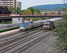 Amtrak's Pennsylvanian entering the Altoona Transportation Center as a Norfolk Southern Railway freight train passes through. Westbound Pennsylvanian at Altoona station, August 2022.jpg