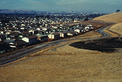 Photographie des années 1960 montrant des maisons neuves toutes identiques situées dans un paysage de steppe subpolaire.