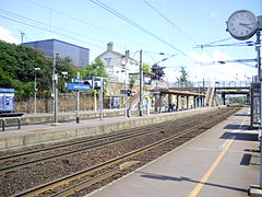 Vue des quais en direction de Paris depuis le quai commun aux voies D et E, avec en surplomb le bâtiment de la gare.