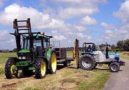 Landini 6860 chargeant des caisses sur une remorque.