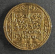 Koin emas dengan pola persegi di dalamnya, beserta kaligrafi Arab.