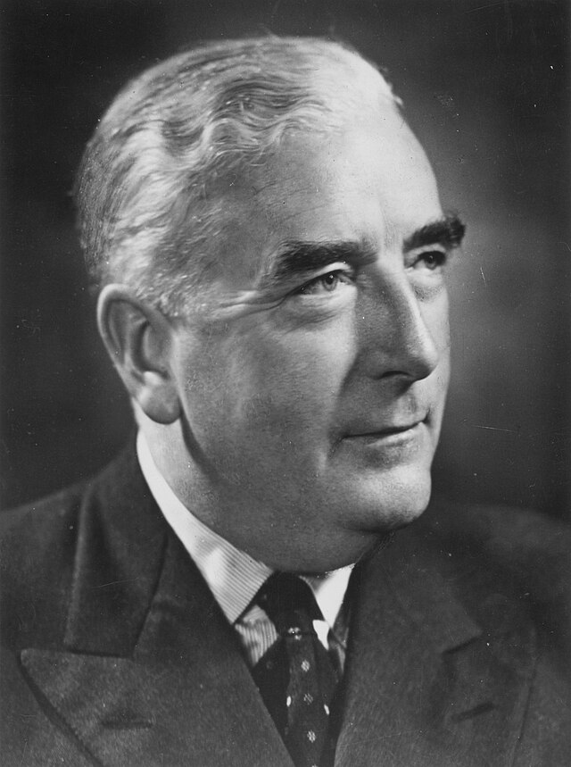 Menzies was thickset elderly Anglo-Saxon man, cleanshaven and wearing a suit.