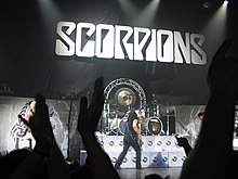 Gli Scorpions in Concerto e il relativo logo sullo sfondo.