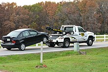 A wheel-lift truck towing a damaged Ford Focus Two car accident temporarily closes Rock Quarry Road (15468506997).jpg