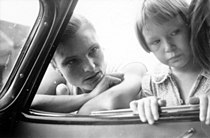 Vrouw en kind kijken naar binnen door het autoraampje (1937)