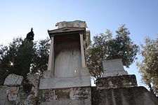 Σύγχρονο αντίγραφο του ταφικού μνημείου του Διονυσίου του Κολλυτού (τέλη 4ου αιώνα π.Χ.). Το πρωτότυπο έργο τέχνης βρίσκεται στο Αρχαιολογικό Μουσείο Κεραμεικού, αυτό το αντίγραφο βρίσκεται στην Οδό των Τάφων στο αρχαίο ελληνικό Κοιμητήριο του Κεραμεικού, Αθήνα.