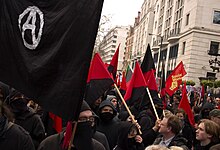 Red-and-black bisected flags at an anti-austerity march in London, 2011 Anarchist 2011 protest.jpg