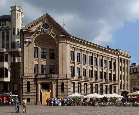 Neoklasicistična art nouveau: Številne stavbe, zgrajene za banke v Rigi, so imele neoklasicistične oblike, kot je ta, zgrajena leta 1913 po načrtih Paula Mandelstamma.[21]