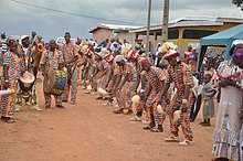 des hommes en uniforme dansent autour du tam-tam