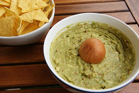 A guacamole mix (right) used as a dip for tortilla chips (left).