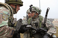 A soldier of the Moldovan Army at the Joint Multinational Readiness Centre in Hohenfels, Germany Moldovan army Capt. Deli Ianec, left, role-playing as an Afghan National Army officer, and U.S. Army Capt. Trey Marsh, with Iron Troop, 3rd Squadron, 2nd Cavalry Regiment, review pictures taken after a search 130311-A-PU716-004.jpg