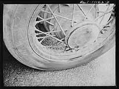 Tire on a car in a parking lot is marked with name of its owner to deter thieves