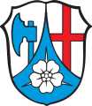 Gemeinde Schlehdorf In Silber eine eingeschweifte blaue Spitze, darin eine silberne Schlehenblüte, vorne ein blaues Beil, hinten ein durchgehendes rotes Kreuz.