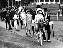 Olive Middleton in a white hat and fur shawl at the back of a procession of dignitaries accompanying Princess Mary in Headingley, Leeds in 1927 1927 - Princess Mary leads local dignitaries in a procession in Headingley, Leeds.jpg