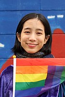 Wen Chen-ling holding an LGBT flag outdoors