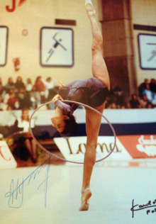 Alexandra Timoshenko executado uma rotina de ginástica olímpica utilizando um bambole durante o torneio pré-olimpico de Alicante em 1992.