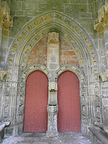 Portail comprenant deux portes jumelles. Sur les paroi latérales, à droite et à gauche, on voit deux des niches vides prévues pour les statues des apôtres.