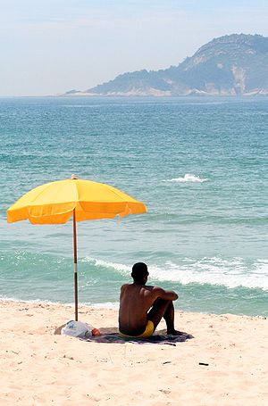 Man sitting under a beach parasol
