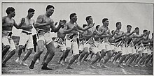 B&W photo of men dancing, chanting