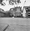 Pastorie, behorende bij de tegenover gelegen N.H.kerk, die door een gemetselde muur verhoogd met kolommen waartussen zich ijzeren staven bevinden, van de openbare weg is gescheiden.