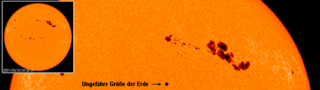 Sonnenflecken im Vergleich zur Größe der Erde. Die größte Fleckengruppe rechts gehört zum Typ F.