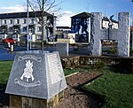 Bild över torget Free Derry Corner sett från norr. På minnesstenen hyllas medlemmar av Provisoriska IRA:s Derrybrigad som dött i strid.