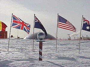 Geografischer Südpol, im Hintergrund die alte Amundsen-Scott-Südpolstation