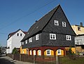 Wohnhaus (Umgebinde) mit Sonnenuhr, dazu Einfriedung