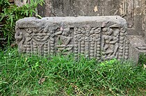 Decorated stone pillar in front of the temple