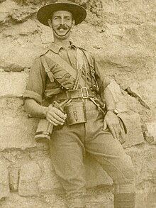 Photographie d'un homme souriant, vêtu d'un costume militaire claire.