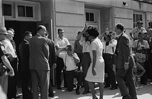 African-American university student Vivian Malone entering the University of Alabama in the U.S. to register for classes as one of the first African-American students to attend the institution. Until 1963, the university was racially segregated and African-American students were not allowed to attend. Vivian Malone registering.jpg