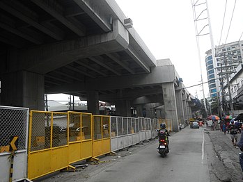 Steel pole 13 (of suspension or flag design, in the foreground) and 14 (of anchor or flag design, in the background) of the transmission line along the east side of the Gregorio Araneta Avenue