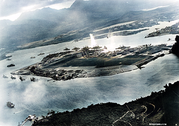 Photo aérienne d'une bataille aéronavale. On aperçoit des avions et des navires en feu.