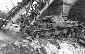 Німецький танк Pz.IV 8-ї танкової дивізії форсує річку Шелонь біля руїн мосту, підірваного саперами капітана Савіна. Липень 1941 р.