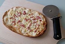 Flammkuchen traditionel: tynd, high grade hvedemel langtidsæltet med vand, salt og olie, uden gær eller andre hævemiddel. Rullet meget tynd ud, belagt med fromage blanc (ikke creme fraiche), røget bacon, snittet løg, og 3 minutter i øvn ved 280 grader Celsius