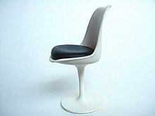 Miniature de la chaise Tulipe sur un fond blanc. Celle-ci se compose d'un pied corolle blanc, d'une coque blanche incurvée. L'assise est noire.