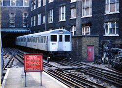 Een metro richting Aldgate komt binnen, links nog een metro op het kopspoor.