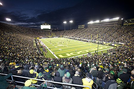 Nighttime panorama of a full stadium during a football game.