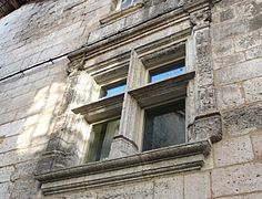 Fenêtre à meneaux encadrée de pilastres sculptés.