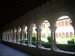 Arcos de medio punto sobre ábacos que unen las dobles columnas; capiteles muy labrados, fustes basas áticas y plinto.