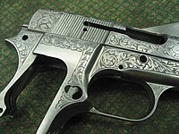 ... o receptor de uma pistola Browning Hi-Power ricamente trabalhados.